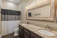 Bathroom with granite coutertops and tub/shower combo.