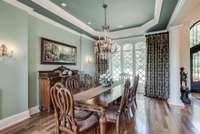 FORMAL DINING SPACE WITH WALL SCONE LIGHTING AND GOLDTONE CHANDLIER