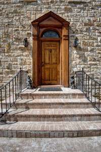 Solid Oak front door with original hardware. Home is constructed with European style crab orchard stone.