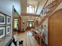 Large Foyer is two stories high with stairs leading to rooms upstairs.