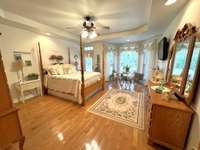 Primary Bedroom with hardwood floors and great sitting area looking into the backyard.