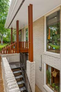 This house has many interest elements including the exterior metal stairs that connect the exterior patio to the lower level of the home.