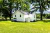 back of home and view of small storage shed