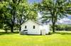 back of home and view of small storage shed