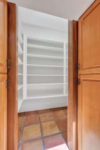 The pantry is tucked away behind two, large cabinet doors.