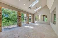 The covered back porch overlooks the wooded back lawn.