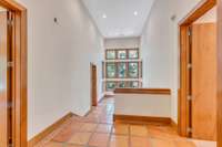 The view captures the hallway to the bedrooms and it's dramatic wall of windows.