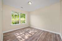 Bedroom #3 features a laminate hardwood flooring and a double window overlooking the front yard area.