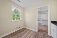 The utility room features a window and cabinet with countertop. It connects through to the kitchen, primary closet as well as the basement.