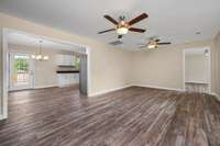 A look from the view of the front door. Here you see how the living room area connects to the dining room and kitchen areas as well as the primary bedroom.