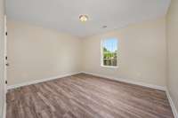 Bedroom #2 features laminate hardwood flooring and a window overlooking the back yard.