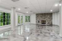 Lower level family/game room with gas fireplace and beautiful Epoxy concrete floors for easy maintenance!