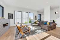 Spacious living room with custom tiled fireplace and large windows to enjoy the natural light