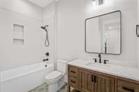 Additional bathroom, attached to the 4th bedroom gives off a rustic feel with it's wood toned furniture style vanity, a herringbone tiled shower & it's rustic patterned floor tile.