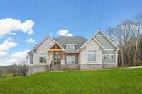 What a stunning home designed with stone, brick & natural wooden tones & details.  *Green grass was edited for MLS purposes - this is an active construction site & landscaping has yet to be completed.