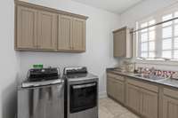 Large utility room located off side pedestrian door for easy mud room with sink