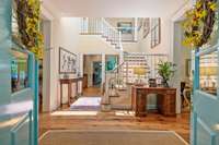 Gracious entry foyer sun-drenched from the 4 skylights in the nearly 25 ft ceiling.  Throughout the main level are 1.5 inch thick antique heart pine flooring and triple crown molding.