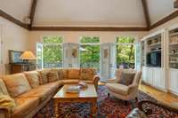 Family room with antique timber beams. French doors are opened to the deck.