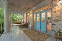 Tuscan columns adorn this expansive porch with dual ceiling fans.