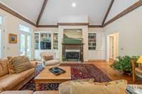 Built-in bookshelves. Gas fireplace. To the right is the hallway with the conveniently located wet bar for entertaining and half bath.