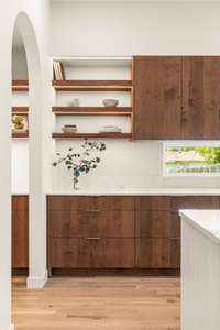 The kitchen boasts designer pendant lights, high-end appliances, a spacious island, floating shelves, and ample storage via the Pinterest-worthy butler's pantry.