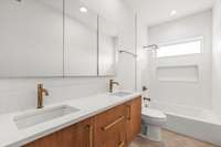 The second-floor guest bathroom boasts a double vanity with a sleek floating cabinet, a tiled rainfall shower, and an extra-wide tub perfect for guests or children.