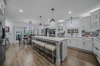 White wood cabinets ground this kitchen with contemporary materials and stainless steel appliances.