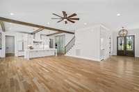 Additional views of the open concept living spaces on the main level. On the right is the front door and entry way area with the kitchen space on the left.