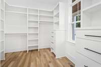 There is so much storage in this primary closet! The dressers are a huge plus and you even have natural light with a window in this room!