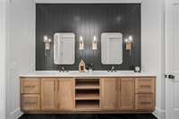 What a stunning custom vanity with tons of storage, open shelving, quartz countertops and elegant matte gold side sconces. A sizable linen closet is located in the corner of the bathroom.