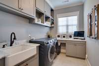 Large utility room with beautiful sink. Built in cabinets. Work space.