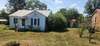 Front view of home from other corner. little building on the right is a shared well that hasn't been used by current seller since they have lived there.