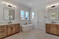 Oversized Primary Bathroom features Separate Vanities, Freestanding Tub, and a Walk In Shower