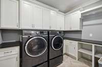 Huge laundry room #2 upstairs with built-ins. Washer and dryer remain.