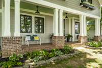 The inviting rocking chair front porch, with its classic brick floor and custom-built window boxes, adds a touch of Southern charm and warmth to the home’s façade. It’s the perfect spot to relax and enjoy the tranquil surroundings.