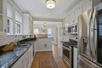 View from the back of the kitchen through the charming swinging door to the Dining Room.