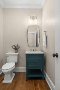 The chic powder room combines style and function, offering a convenient and elegant space for guests to refresh themselves in privacy. High-end finishes and a tasteful design with an unexpected pop of color make it a standout feature of this home.