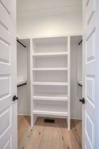 Custom his and her closet spaces too! This is just one of the two primary bedroom closets.