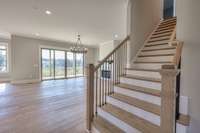 Beyond the entry foyer and staircase, take a peek into the expansive living room overlooking one of TWO outdoor living areas.