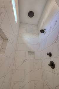 Beautiful tile rain shower with niches are perfect for keeping things close and organized.