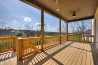 Main floor covered deck with stair access to the backyard and basement living areas.