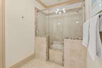 They share a beautiful soaking tub/shower room with marble surround and stunning glass walls and door with decorative glass tile accents.