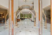 The grand foyer and floating dual staircase welcome you into the home.