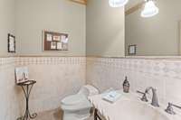 The wine cellar half bath has a lovely stone sink and vanity with iron base and a drain located outside of left wall for possible expansion to full bath.