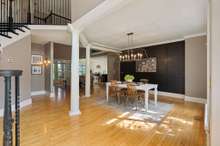 A formal dining room with upgraded lighting and decorative board and batten accent wall provides plenty of space for gatherings