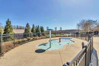 Kiddie pool with fountains, fenced off from main pool area for children's safety.