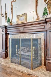 Beautiful oversized mahogany gas fireplace with chocolate granite surround.