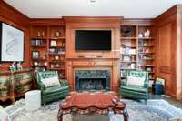 Walnut paneling and built in shelving throughout.  Lovely gas fireplace with green granite surround.