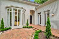 Entry of house in the middle flanked by the bay window of the living room and double french doors of the dining room.