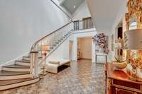 Elegant curved staircase, parquet floors and double height ceilings with skylights.